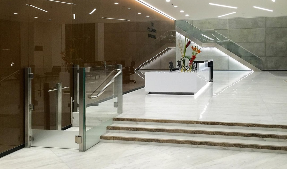 a modern lobby with a marble floor and stairs.