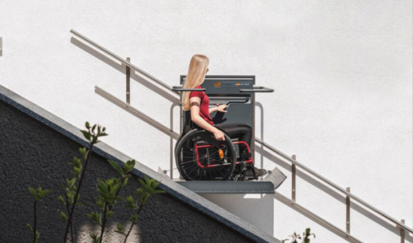 a woman in a wheel chair on top of a stair case.