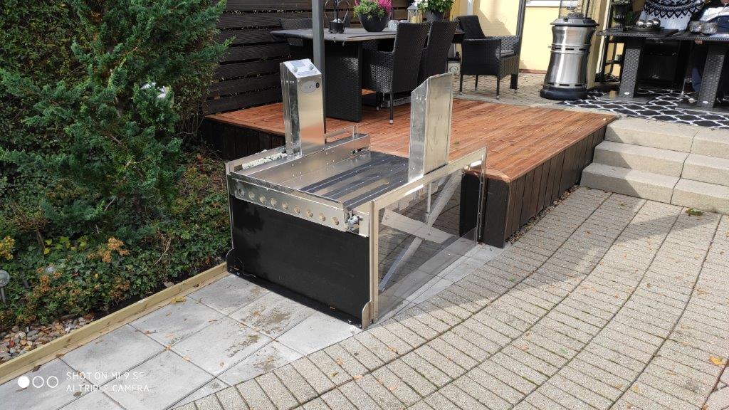 a metal table sitting on top of a wooden platform.